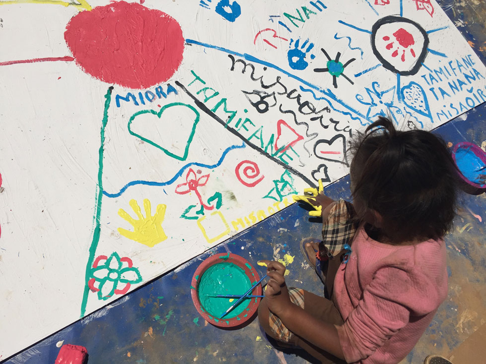 little girl participating in a fresco on children's rights in Nosy Be